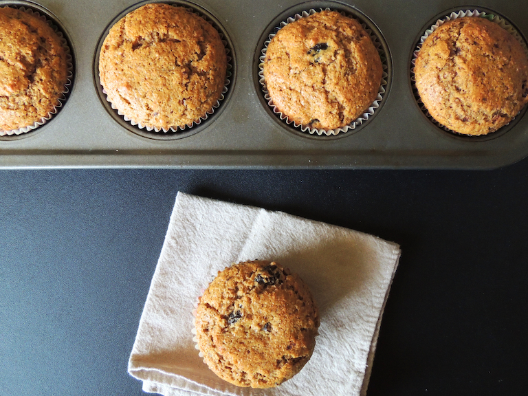 4 muffins in a baking tin and one on a cloth napkin