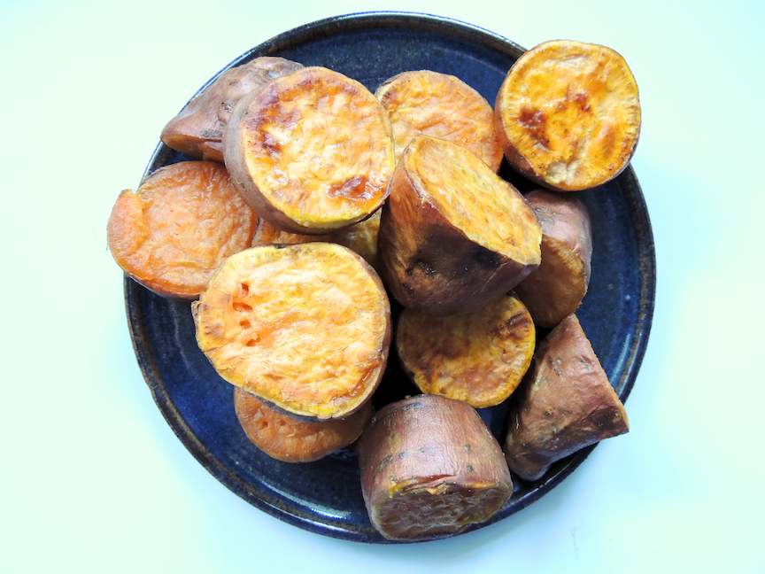 sliced and roasted sweet potatoes on a blue plate